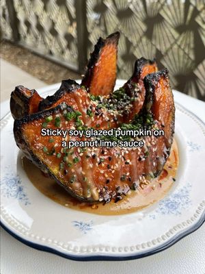 Sticky soy glazed squash/pumpkin on the creamiest peanut lime sauce (and some steamy rice if that floats your boat) ✨ RECIPE ½ kabocha squash Olive oil and salt 2 tbsp hoisin 2 tosp sriracha 1 tbsp agave 1 tosp soy ½ tbsp rice vinegar 1 tsp sesame oil 1 garlic clove, grated 1 inch piece peeled ginger, grated 100g smooth peanut butter 2 tbsp water (more if needed) 3 tbsp soy sauce 1 lime juice 2 tsp agave To garnish: 1 tbsp white sesame seeds 1 tbsp black sesame seeds 1 tbsp chopped chives Your favourite chilli crisp 1. Preheat the oven to 180 fan or 200C. Take half the squash and remove the seeds. Cut it into 4-5 thick wedges, leaving the skin on. Place the wedges onto a tray, drizzle with a splash of oil and salt then place into the oven to roast for 45 min. 2. Whisk together all the ingredients for the glaze. After 45 minutes baste the squash wedges with the sticky glaze. Repeat again after 10 mins then switch to grill to caramelise the sauce. Baste as many times as you want to get a nice thick coating of the sauce. 3. Quickly whisk together the ingredients for the peanut sauce then get ready to plate. 4. Whilst the squash is still on the tray, sprinkle over mixed sesame seeds and finely chopped chives. 5. Serve on a bed of the peanut sauce and dive in! #squashrecipes #pumpkinseason #easyveganrecipes #veganmeals 