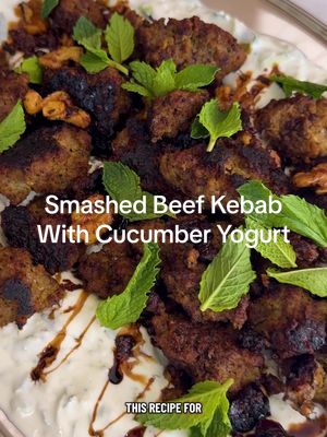Here's how to make Smashed Beef Kebab With Cucumber Yogurt: • 2 cups full-fat or low-fat Greek yogurt (about 16 ounces) • 2 mini cucumbers (about ½ pound), grated on the large holes of a box grater • 3 tablespoons finely chopped mint, plus mint leaves for serving • 1 large garlic clove, finely grated • 1 pound ground beef (preferably 80% lean) or ground lamb • 1 small yellow onion, grated on the large holes of a box grater (see Tip) • ½ teaspoon ground turmeric • 2 teaspoons kosher salt (such as Diamond Crystal) • Freshly ground black pepper • ¼ cup walnut halves or pieces, or both (see Tip) • 2 tablespoons raisins or dried cranberries • Pomegranate molasses, optional, for serving • Warmed pita or white rice, for serving Add the yogurt, cucumbers, chopped mint and garlic to a medium bowl. Mix well to combine. Chill until ready to serve. Add the beef, onion, turmeric, 1 teaspoon of salt and lots of black pepper to a second medium bowl and mix well to combine. Heat a large well-seasoned cast-iron skillet (or other large heavy-bottomed pan) over medium-high. Once the skillet is very hot, divide beef into large, irregular chunks by using two spoons or your hands and drop into the skillet. Cook, undisturbed, until charred and crisp on the underside and browned at least halfway up the sides, 6 to 8 minutes. Using a wooden spoon, toss the meat, breaking up any very large pieces. Add the walnuts and raisins and continue to cook, stirring often, until the meat is cooked to desired doneness and the walnuts are toasted, 2 to 3 minutes more. Remove the yogurt from the fridge and season with the remaining 1 teaspoon of salt. Spread the yogurt on the bottom of a serving platter and top with the crispy meat. Finish with a drizzle of pomegranate molasses, if using, and garnish with mint leaves. Serve with warmed pita or rice. Tips: To minimize eye irritation while grating, use a chilled onion. Two tablespoons of pistachios or pine nuts can be substituted for the walnuts.