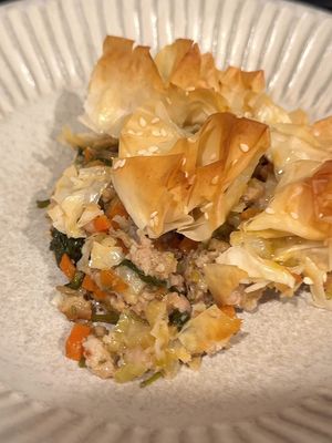 I’m so glad my brain told me to bring this recipe to life. Holy shit was it good! 😂 Basically it’s a savory sausage roll pie. 💯 Full recipe below! ✨For the Sausage✨ 2 lbs Italian pork sausage 3 Tbsp Dijon mustard 2 Tbsp chopped fresh sage 2 Tbsp chopped fresh rosemary 2 tsp fresh lemon zest 1 tsp ground mace 1 tsp kosher salt ½ tsp black pepper ✨Remaining Filling Ingredients✨ 2 Tbsp olive oil 1 large leek, thinly sliced 1 sweet onion, halved and thinly sliced 2 large carrots, diced ½ cup dry white wine 1 Tbsp flour 1 bag fresh baby spinach Kosher salt Freshly ground black pepper ✨For the Phyllo✨ ~6 sheets of phyllo dough, defrosted, broken into squares 3 Tbsp unsalted butter, melted 2-3 tsp sesame seeds 1️⃣ MIX THE FILLING. Preheat oven to 400°F (205°C). In a large bowl, mix together sausage, Dijon mustard, herbs, and spices until very well blended. 2️⃣ COOK THE VEGGIES. Heat 2 Tbsp olive oil in a large pan over medium heat, then add sliced leeks, onion, and carrots. Season lightly with salt and pepper, then cook, stirring often, until softened, about 4-6 minutes. Use a spatula to clear the center of the pan, pushing the edges to the sides. 3️⃣ ADD SAUSAGE. Raise the heat to medium-high, add all of the sausage to the pan, then cook it, alongside the veggies, until browned on all sides and mostly cooked through. 4️⃣ DEGLAZE WITH WINE. Pour in ½ cup white wine and use a spatula to scrape any browned bits off the bottom. Allow the wine room to reduce by half, then sprinkle in the flour. Stir well. 5️⃣ ADD SPINACH. Add an entire bag of baby spinach, cook until wilted, stirring occasionally, then turn off the heat. Taste and adjust seasoning as needed. 6️⃣ TOP WITH PHYLLO. Cut or break a slice of defrosted phyllo into small pieces (roughly 3-inch squares), then crumble and place on top of the filling with the edges facing up. Repeat until the entire pan is filled with phyllo. 7️⃣ BAKE. Brush melted butter lightly all over the phyllo, then sprinkle with sesame seeds. Bake for about 30-40 minutes, until the phyllo is golden brown and impossibly crispy. Dig in while hot! #dinneridea #sausagerolls #phyllo #easydinner #comfortfood