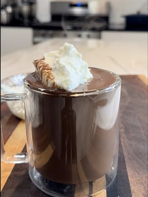If you make hot chocolate with water… you’re choosing to struggle on purpose. Seek warmth immediately. And for the record, this French-style version goes all the way back to 1600s Paris before it made its way to the U.S. through traveling chefs. ☕️ 🔥🤌🏾 Homemade French Hot Chocolate Ingredients 9 oz high-quality 70% dark chocolate, finely chopped 1 cup heavy cream 1 cup whole milk 1 tbsp sugar (more if you like it sweeter) Tiny pinch of salt 1 shot espresso (optional, but incredible) ½ tsp vanilla bean paste Homemade whipped cream (see note) Extra chocolate for shaving Instructions In a saucepan over medium heat, combine the heavy cream, whole milk, sugar, salt, and espresso. Whisk gently as it warms — you want it steaming with tiny bubbles around the edges, but do not let it boil. Once the mixture is hot, turn the heat down and add the chopped chocolate. Whisk until it melts completely and becomes thick, glossy, and smooth. Stir in the vanilla bean paste, then finish by folding in a generous spoonful of homemade whipped cream to give it that classic French richness. Pour into your favorite mug and top with more whipped cream. For presentation, shave a little dark chocolate over the top. Homemade Whipped Cream: Whip 1 cup cold heavy cream + 1 tbsp sugar + splash of vanilla until soft peaks form. You can use a hand whisk, hand mixer, or stand mixer — all three work. Just keep the cream cold for the best texture. #hotchocolate #chocolate #drinks #homemade #foodtiktok 