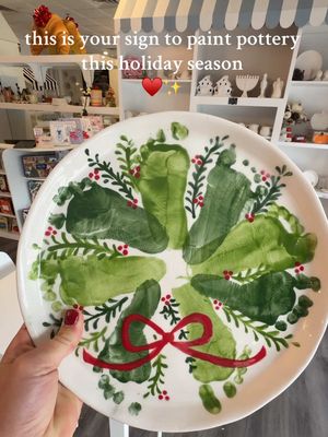 Love that we will have his little toes on a plate forever 🥹♥️✨ If you want to make a footprint wreath plate this year, here are 3 tips to save your sanity (and your sweater sleeves): 1️⃣ Bring two adults. One to hold the baby, and the other to paint the foot and press it down. It makes the footprint way more precise, and the “holder” can wipe feet between moments of adorable chaos. 2️⃣ Alternate feet + colors. Use left foot for four footprints and right foot for four footprints. This helps your wreath look balanced and intentional — even if the process felt… not that. Two shades of green also make it extra pretty! 3️⃣ Paint in two sessions. Session 1: get those precious footprints. Session 2: come back after it dries to paint the bow + details without rushing. Baby already gave you their best behavior the first time, so you can let them move on to a new activity while you finish creating your masterpiece. 🎀 Here’s to tiny toes, holiday memories, and pottery projects that turn out even sweeter than you imagined. ✨ 📍 @My Poterie Austin  #christmasplate #paintingpottery #babyfootprint #christmaspottery #wreathfootprintplate