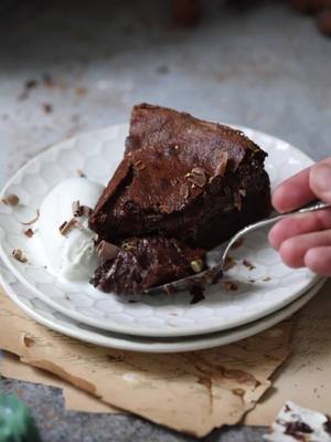 This molten chocolate cake is a rich, decadent treat that any chocolate fanatic will adore! The warm, gooey center is perfect when served with ice cream, and makes for a delicious holiday dessert ❤️ Molten Chocolate Cake Ingredients For the cake: 226g (2 sticks) salted butter 320g semisweet chocolate 1/2 cup cocoa powder Pinch of salt 8 large eggs 1 1/2 cups granulated sugar, divided (or 2 cups, if you want it more sweet) 4 tbsp all-purpose flour Pistachio cream (optional)*   Instructions Preheat the oven to 350 degrees. Butter a 23cm (9-inch) round springform pan and line the base with parchment paper. Cut the butter and chocolate into pieces and melt together in a bowl set over a pot of simmering water (bain marie), stirring every 30 seconds, until smooth. Once the mixture is smooth, sift in cocoa powder and salt and stir to combine. Set aside. Separate the eggs, putting the whites into a large bowl of a stand mixer and the yolks into another medium bowl. Combine the egg yolks with 1 cup of sugar and whisk vigorously until the mixture becomes pale and fluffy. Set aside.  Meanwhile, use a stand or handheld mixer to beat the egg whites, gradually adding the remaining sugar. Continue mixing until the egg whites have stiff, glossy peaks. You should now have three bowls that need to be mixed together. First, pour the melted chocolate mixture into the egg yolks and stir gently until fully incorporated. Then, slowly add about a third of the egg whites into the chocolate mixture and gently fold. Add the remaining egg whites and continue folding gently until the entire mixture is combined and no streaks of egg white remain. Try to keep as much air in the batter as possible.  Pour about 1/3 of the cake batter back into another bowl to set aside for later. Add 2 Tbsp of flour to the remaining 2/3 of the batter and mix well, still being careful to preserve the air in the mixture. Pour the batter with the flour added into the prepared springform pan and bake for about 25-30 minutes, or until the cake is well risen and baked through. Remove from the oven and allow cake to cool in the tin for about 15 minutes. Leave the oven on during this time.  *Pour the remaining 1/3 of the batter on top of the baked cake, spreading it gently to the edges. Return the cake to the oven for another 10-15  minutes, or until a thin crust has just formed on the top of the cake, but the batter is still very soft underneath. Remove from the oven and allow to cool slightly before serving. Remove the ring mold and slice into wedges. Serve warm with vanilla ice cream and fresh fruit, if desired. Bon appetit! *Note: I spread the pistachio cream on the cake after its first bake, then added the remaining batter on top.