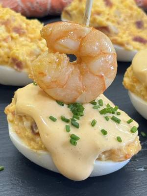 Huevos rellenos con gambas a ajillo y jamón ibérico! El aperitivo navideño más original. Nadie pidió reinventar los huevos rellenos, pero alguien tenía que meterles gambas al ajillo y jamón ibérico. Hay platos que no son para sorprender, son para que te hagan la ola y te pidan la receta. Anímate con este aperitivo tan resultón para triunfar estas navidades!! • INGREDIENTES: 8 huevos 150 grs. jamón ibérico lonchas 24 gambas o langostinos 6 dientes de ajo 60 ml. AOVE • MAYONESA DE AJILLO: El aceite del ajillo (*) 80 ml. aceite girasol 2 huevos Sal • Pela las gambas y resérvalas. Pon aceite de oliva en una sartén y saltea las cáscaras/cabezas de las gambas extrayendo todos los jugos, cuela todo el aceite y resérvalo para la mayonesa (deja que se enfríe). Cuece los huevos 9 mins., pela y parte a la mitad. Para la mayonesa, pon el aceite del ajillo (*) que tienes reservado, agrega dos huevos y sal, ve batiendo poco a poco para que vaya emulsionando y vierte más aceite de girasol hasta que la mayonesa tenga la textura que prefieras. • Trocea finamente las lonchas de jamón ibérico y las gambas/chips de ajo (reserva unas pocas gambas para decorar los huevos), añádeselos a las yemas machacadas, agrega un poco de mayonesa y mezcla todo. Para el montaje, rellena los huevos, napa con la mayonesa casera, un poco de cebollino fresco picado y una gamba con un palillo para terminar. •