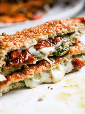 High Protein Chicken Hot Pockets 🍗🥬🍅 Remember those frozen hot pockets from childhood? These are like the glow-up version — cheesy, herby, and packed with protein.  They’re made with ground chicken instead of dough, so you get all the melty, comfort food vibes without the crash. INGREDIENTS (Makes 2) -  450 g ground chicken 1 tsp paprika 1 tsp garlic powder 1 tsp onion powder 1 tsp italian seasoning ½ tsp salt ½ tsp black pepper 2 tbsp pesto spinach red onion ¼ cup sundried tomatoes ½ cup mozzarella cheese shredded ¼ cup parmesan cheese grated DIRECTIONS - 1) In a mixing bowl, combine the ground chicken with paprika, garlic powder, onion powder, Italian seasoning, salt, and pepper. Mix until fully incorporated. 2) Place a sheet of parchment paper on a flat surface and add half the chicken mixture on top. This recipe makes 2 chicken hot pockets so use half the ingredients for everything. 3) Lay a second sheet of parchment over the chicken and roll it into a thin rectangle using a rolling pin. 4) Remove the top sheet of parchment and add half the toppings to one half of the chicken rectangle (pesto, spinach, red onion, sundried tomatoes, and mozzarella cheese). 5) Fold the parchment over so the chicken layer covers the toppings, forming a sealed pocket. 6) Press the edges with a fork to secure and fully seal the hot pocket. 7) Sprinkle half the parmesan over the top, gently pressing to help them adhere. 8) Transfer to the air fryer and cook at 375°F for 12–15 minutes, or until fully cooked through. 9) Repeat the process for the second hot pocket. Slice and serve warm. #highproteinrecipes #healthydinnerrecipe #chickenhotpockets #proteinmeals #highproteindinner