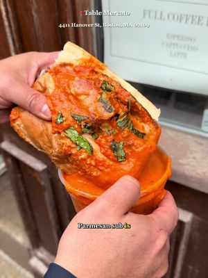 Our Favorite Bites in 📍Boston, Ma - @tablemercato  Hi cuties … if you haven’t had the Spicy Vodka Parmesan Sub from Table Mercato, are you even eating in the North End? Jen Royle doesn’t do “light lunches,” and this massive sandwich is proof. Here is exactly what’s tucked inside this masterpiece: - Signature Chicken Cutlets: Famous for being extra thick, extra crispy, and all white meat. -Spicy Vodka Sauce: A creamy, dreamy tomato sauce with a kick of heat (those Calabrian chilis don’t play). - Fresh Mozzarella: Massive, melted slices of high-quality mozz. - Imported Parmesan: A heavy-handed dusting of the good stuff. - Fresh Basil: Because we’re fancy like that. - The Roll: Perfectly toasted (I always go for the sesame seed!). 📍 Table Mercato  441 Hanover St, Boston, MA 02109 Let us know how your experience went!  Cheers bbs  #cornersofboston #bostontiktok #bostonfood #sandwich #fyp 