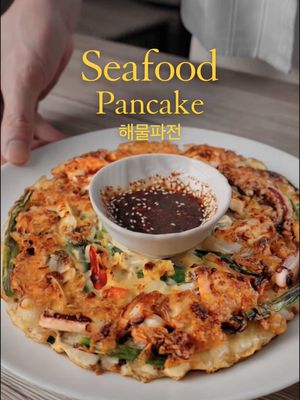 Full Recipe & Macros Below 👇🏻 Korean Seafood Pancake (Haemul Pajeon) 🇰🇷 (2 Servings) Per Serving: ~340 kcal | 22P | 34C | 14F ⸻ Ingredients • 1 cup Frozen Seafood Medley (shrimp, mussels, squid — thawed & patted dry) • 1 cup All-Purpose Flour • 2 tbsp Potato Starch (for crispiness) • 1 large Egg • ¾ cup Cold Water (add gradually) • 1 bunch Green Onions (cut into 2–3 inch lengths) • ½ tsp Salt • ¼ tsp Black Pepper • Optional: ¼ tsp Garlic Powder • Neutral oil (for frying) Optional Dipping Sauce • 2 tbsp Soy Sauce • 1 tbsp Rice Vinegar • ½ tsp Sesame Oil • Optional: pinch of chili flakes or gochugaru ⸻ Directions 1. In a bowl, mix flour, cornstarch, salt, pepper, and garlic powder (if using). 2. Add the egg and slowly whisk in cold water until you get a thin but cohesive batter (similar to crepe batter). 3. Fold in the green onions and seafood medley, making sure everything is evenly coated. 4. Heat a non-stick or cast-iron pan over medium-high heat and add a generous layer of oil. 5. Pour the batter into the pan and spread it out evenly into a thin pancake. 6. Cook for 3–4 minutes until the bottom is golden brown and crispy. 7. Flip carefully and cook another 3–4 minutes, pressing lightly with a spatula to crisp it up. 8. Remove from pan, rest for 1 minute, then slice into wedges. 9. Mix dipping sauce ingredients and serve on the side. #asianfood #koreanfood #asianrecipes #EasyRecipes 