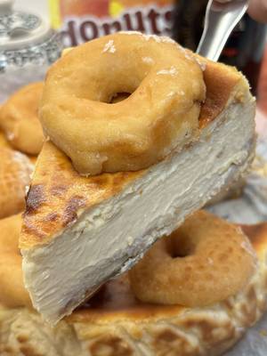 Cheesecake de donuts! Las tartas de queso son de esos postres que nunca fallan: fáciles, resultonas y capaces de alegrarte cualquier día. Pero la de hoy juega en otra liga… una riquísima cheesecake de donuts, con todo el sabor del glaseado de siempre metido dentro de una tarta cremosa y suave que es pura fantasía. Te aviso: cuando la pruebes vas a querer más porque está IMPRESIONANTE!! • INGREDIENTES (molde 23cms): 600 grs. queso crema (tipo Philadelphia) 400 grs. nata de montar (35%) 4 donuts 4 huevos L 120 grs. azúcar • PARA LA BASE: 6/7 donuts • En primer lugar, forma la base de la tarta en un molde previamente forrado con papel sulfurizado (papel de horno) coloca los donuts, procurando no dejar huecos, y aplástalos ligeramente con la base de un vaso para formar la base. Precalienta el horno a 180º (calor arriba/abajo). En un bowl amplio pon el queso crema, los huevos, azúcar, la nata y los cuatro donuts troceados. Mezcla todo bien con la batidora tratando de no airear demasiado la mezcla y así no crear burbujas. Vierte la mezcla resultante dentro del molde sobre la base de donuts que tienes hecha. • Hornéalo durante 45/50 minutos (45 un poco más cremosa) mientras tú, cómodamente, te sientas en el sofá a ver la tele o una peli. Cuando termine el tiempo de horneado, y de forma opcional, puedes darle un par de minutos al grill para que la parte superior coja un bonito color dorado, retira y deja templar (verás que tiembla mucho, no te preocupes que luego cuando repose se asentará). Mete en la nevera y consume al día siguiente. Antes de servir, decora con mini donuts partidos a la mitad horizontalmente. Ahora sí, coge una cucharilla y prepárate para sentir un orgasmo gastronómico de proporciones bíblicas… si sobrevives, nos vemos en la siguiente receta!!! •