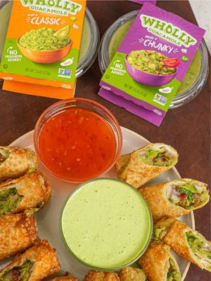#WHOLLYGuacamoleBrandPartner Lunar New Year is right around the corner and making egg rolls signifies all the wealth you’ll receive this year! I’m putting a fun twist on egg rolls by using @WHOLLY® Guacamole Chunky Guacamole as the base of the filling for my Lunar New Year Avocado Egg Rolls – made with real, ripe hand-scooped avocados and non-GMO ingredients with ingredients you can actually pronounce! Serve them with a creamy cilantro ranch or sweet chili sauce and enjoy! Lunar New Year Avocado Egg Rolls Makes about 10 egg rolls 2 WHOLLY® Guacamole Chunky 7.5 ounce ½ cup sun-dried tomatoes, chopped 1 small red onion, diced 2 tablespoons cilantro, chopped 1 lime, juiced ½ tsp White Pepper 2 tablespoons Fish Sauce 10 egg roll wrappers 1 large egg, beaten 1 quart canola oil Serve with sweet thai chili sauce or a creamy cilantro ranch 1. In a large bowl, add the WHOLLY® guacamole along with the sun-dried tomatoes, onion, cilantro, lime juice, white pepper, and fish sauce. Mix until just combined and set aside. 2. In a small bowl, beat the egg and add 1 tablespoon of water then mix to combine. 3. Lay the egg roll wrappers and working one at a time, lay 2 tablespoons of filling in the bottom third of the egg roll wrapper with the bottom corner facing you. Fold the corner over the filling and form it into a log shape, removing any excess air, then roll the egg roll one full roll. Tuck in the left and right corners, brush the top of the wrapper with egg wash then seal the egg roll tightly. Repeat until all the egg rolls are wrapped. 4.  In a heavy bottomed pot, heat the oil over medium high heat to 350°F, then fry the egg rolls in batches for 3-5 minutes until golden brown and puffed up. Remove them from the oil and lay on a wire rack to drain. 5.  Serve the egg rolls with sweet thai chili sauce or a creamy cilantro ranch and enjoy!