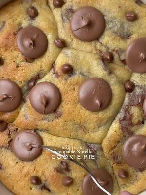 Ooey-Gooey Scoopable Nutella Cookie Pie🤤 Yields: 15-16 Chunky Cookies INGREDIENTS:  230g Cold Chopped Unsalted Butter  160g Caster Sugar  160g Light Brown Sugar  450g Chocolate Chunks or chips  475g Plain Flour  1 tsp Salt 3 tsp Baking Powder  3/4 tsp Baking Soda  2 Eggs  1 Egg Yolk  1 tsp Vanilla  INSTRUCTIONS: •Cut cling wrap into small squares. Scoop ½ teaspoon Nutella onto individual cling-wrap squares. Fold to seal and freeze until solid. (Repeat for however many Nutella stuffed cookies you plan to make.) •In a large mixing bowl, add the cold cubed butter and whisk until slightly creamy. Add the white sugar and light brown sugar, then whisk together until well combined and fluffy. •Add the eggs, vanilla extract, and chocolate chips or chunks. Whisk until fully incorporated. •Add the flour, baking powder, baking soda, and salt. Gently mix until just combined, do not overmix. •Portion the dough into 90g balls. Press a frozen Nutella piece into the centre of each dough ball, seal well, and roll into a smooth ball. •Place the stuffed cookie dough balls onto a tray and freeze for at least 30 minutes (or overnight for best results). •Preheat oven to 180°C (350°F). •Take any shape baking dish circle, square, rectangle anything and line it with parchment paper. Arrange frozen cookie dough balls in it leaving some space between them. •Bake for 10-15 minutes (timing depends on the type of pan) or until the tops are lightly golden while the centres remain soft and gooey. •Remove from the oven and let cool slightly. •Serve warm with ice cream and chocolate sauce enjoy!✨ NOTE: Store any extra dough balls in an airtight container or freezer bag and freeze for later. Whenever a cookie craving hits, bake straight from frozen🫶🏻 #cookie #nutella #cookiepie #fyp #viral 