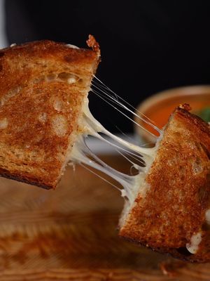 This grilled cheese is everything you want — crispy, buttery bread with melted white cheddar pulling apart in the middle. Simple, comforting, and impossible to mess up. Pair it with roasted tomato soup and you’re set. Roasted Tomato Soup Ingredients • 6–8 field tomatoes (depending on size) • 2 red bell peppers • 1 large white onion • 1 whole head of garlic, top sliced off to expose cloves • 2–3 tbsp olive oil • ½ tsp chili flakes (or to taste) • Salt & freshly cracked black pepper • ¼–½ cup cream (to taste) • Fresh basil, to finish Grilled Cheese Ingredients • 2 slices quality sourdough (Baldwin sourdough from Blackbird Baking Co.) • ~1 cup grated white cheddar (medium) • Butter, generous Method; Preheat oven to 425°F. Place tomatoes, peppers, onion, and garlic on a baking tray. Drizzle with olive oil, season with salt, pepper, and chili flakes. Roast for 25–30 minutes until soft and nicely caramelized. Transfer roasted vegetables (squeeze garlic from skins) to a blender. Blend until very smooth, working in batches if needed. Add cream, adjust seasoning, and blend again. Finish with fresh basil, extra chili flakes, and an optional drizzle of cream. For the grilled cheese, butter the outside of the bread, add cheddar, and cook in a pan over low–medium heat until golden brown and fully melted inside. Slice and serve hot with the soup. #grilledcheese #tomatosoup #EasyRecipes #torontochef 