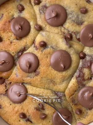 Ooey-Gooey Scoopable Nutella cookie pie🤤 Yields: 15-16 Chunky Cookies INGREDIENTS: 230g Cold Chopped Unsalted Butter 160g Caster Sugar 160g Light Brown Sugar 450g Chocolate Chunks or chips 475g Plain Flour 1 tsp Salt 3 tsp Baking Powder 3/4 tsp Baking Soda 2 Eggs 1 Egg Yolk 1 tsp Vanilla INSTRUCTIONS: •Cut cling wrap into small squares. Scoop ½ teaspoon Nutella onto individual cling-wrap squares. Fold to seal and freeze until solid. (Repeat for however many Nutella stuffed cookies you plan to make.) •In a large mixing bowl, add the cold cubed butter and whisk until slightly creamy. Add the white sugar and light brown sugar, then whisk together until well combined and fluffy. •Add the eggs, vanilla extract, and chocolate chips or chunks. Whisk until fully incorporated. •Add the flour, baking powder, baking soda, and salt. Gently mix until just combined, do not overmix. •Portion the dough into 90g balls. Press a frozen Nutella piece into the centre of each dough ball, seal well, and roll into a smooth ball. •Place the stuffed cookie dough balls onto a tray and freeze for at least 30 minutes (or overnight for best results). •Preheat oven to 180°C (350°F). •Take any shape baking dish circle, square, rectangle anything and line it with parchment paper. Arrange frozen cookie dough balls in it leaving some space between them. •Bake for 10-15 minutes (timing depends on the type of pan) or until the tops are lightly golden while the centres remain soft and gooey. •Remove from the oven and let cool slightly. •Serve warm with ice cream and chocolate sauce enjoy!✨ NOTE: Store any extra dough balls in an airtight container or freezer bag and freeze for later. Whenever a cookie craving hits, bake straight from frozen 🫶🏻 #cookie #nutella #chocolate #fyp #viral 