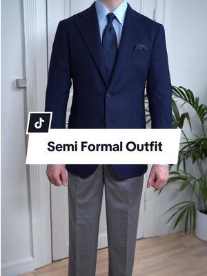 Semi-formal outfit idea built around one of the most timeless colour combinations: grey and navy. Grey high-waisted flannel trousers paired with a light blue shirt and a navy tie create a clean, balanced foundation. Black penny loafers keep it refined without feeling too formal, while a steel-blue watch subtly ties everything together. To finish the look, add a classic navy jacket in 100% Italian wool — structured, versatile, and effortless. #menswear #mensfashion #mensstyle 