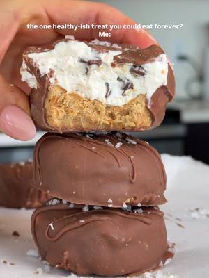 The bestttt healthy-ish, no bake protein cookie dough cups! For easier to read instructions, I recommend going to my blog for the recipe (linked in my bio!) Cookie dough 3/4 cup almond or peanut butter 1/3 cup protein powder 1-2 tbsp almond flour, as needed (you may not need to add this!)  3 tbsp maple syrup or honey 1 tbsp melted coconut oil 1 tsp vanilla extract & good pinch of sea salt Filling 1 container of So Delicious Coconut Whip (or other whipped topping) 1 1/2-2 scoops of your favorite vanilla protein powder *optional! 1 tsp vanilla extract Chocolate coating 1 cup chocolate chips 2 tsp coconut oil   In a bowl, mix together the protein powder, nut butter, maple syrup, vanilla, and salt. If your dough is super sticky, add in the almond flour and mix well. It shouldn't be dry, but shouldn't stick to your fingers! Divide the dough amongst a muffin tin, pressing it into the bottoms and filling them about 1/2 way full. Scoop about 2/3 of the coconut whip out into a large bowl. Add the protein powder, and vanilla and whip until fluffy. Then fold in the chocolate chips. Spread over the cookie dough layers, filling them the rest of the way full. Freeze for 4-5 hours or overnight! Melt chocolate chips and coconut oil together. Remove bars from the freezer, and dip each bar in melted chocolate. Place on parchment-lined baking sheet or plate and place back in the freezer until set. #healthydessert #cookiedough #nobakedessert #highproteinrecipes #highprotein