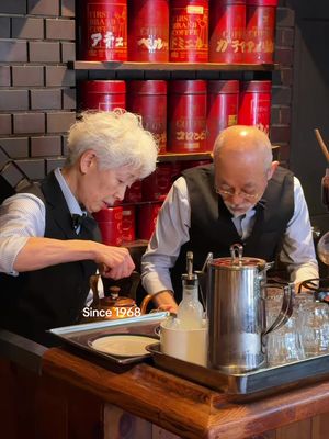A Tokyo café run by the same couple for 50+ years ☕️ It’s one of those places you’d definitely notice from the outside—muted green facade, red awning, and those little window details. Inside, warm sunlight through the arched windows and shelves lined with old red coffee tins. Run by Junichi Miyamoto and his wife Fusako since 1968. He makes the coffee, she makes the cakes and sandwiches. Loved the thick-cut toast with different jams and black coffee. Simple but just right! 📍Shanty, Tokyo 💴 Coffee ~ ¥550 ($3), toast ~ ¥650 ($4), morning set ¥650 ($4) 🕰️ 10am–6pm, closed Wed & Thu . #kissaten #japantravel #tokyo #cafe #tokyotravel 