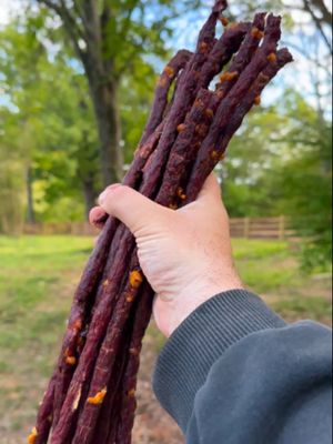 Homemade Beef Sticks 👇 Recipe: Servings: 6 people Prep: 1 hour Cook: 5 hours Ingredients: Beef 5 lbs 90/10 ground beef 10 oz cheddar cheese, small cubes 3-4 fresh jalapeños, finely diced ⅓ cup Cowboy Butter Rub Binder & Cure 1 tsp Prague Powder #1 1/2 cup ice water Instructions Combine ground beef, seasoning, cure, and binder. Add ice water slowly while mixing. Mix aggressively until the meat becomes tacky/sticky. Fold in the cheese & jalapeños at the end until well incorporated. Load the meat into a jerky gun. Grease some wire cooking racks and press out long ropes of the beef sticks with spacing between. Make sure to go slow and steady to not create breakage. Add to your smoker at 130F for one hour to dry the outside and create a pellicle. Bump up the heat 10F every hour until the smoker gets to 170F. Let cook until the beef sticks are at least 150F internal. Cooking should take about 5-6 hours total. (Optional) In the last hour, brush with beef tallow to get some extra flavor and shine if you like. Once done, pull off and place in the fridge to cool for at least 2 hours. Serve and enjoy!