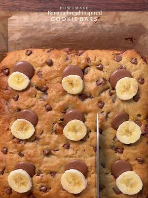 Banana bread inspired cookie bars🤤 INGREDIENTS: •100g cold unsalted butter (cubed) •80g caster sugar •65g light brown sugar •85g very ripe mashed banana •1 whole egg •1 tsp vanilla  •250g plain flour •1/2 tsp cinnamon powder  •1/2 tsp instant coffee powder  •1/2 tsp baking powder  •1/4 tsp salt •1/4 baking soda  •150g chocolate chunks INSTRUCTIONS: •In a large mixing bowl, add the cold cubed butter and whisk until slightly creamy. Add the white sugar and light brown sugar, then whisk together until well combined and fluffy. •Add the egg, vanilla extract, Mashed banana and chocolate chips or chunks. Whisk until fully incorporated. •Add the flour, baking powder, baking soda, and salt. Gently mix until just combined, do not overmix. •Place the cookie dough balls onto a 8*8 Square tray  •Preheat oven to 180C (350°F). Bake for 30-35 minutes or until the tops are lightly golden while the centres remain soft. **If the top turns golden but the inside is still very raw, cover it loosely with foil and continue baking** •Remove from the oven and top it up with more chocolate chips, banana pieces and let cool slightly. •Serve warm with ice cream🤤 #cookie #bananabread #fyp #explorepage✨ #desserts 