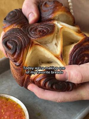 Crispy outside, soft like a cloud inside, baked in a pot… meet KUBANEH. Think if a croissant and challah had a baby! The dough is made with my favorite bread flour @Bob’s Red Mill and layered with butter and honey, shaped as roses, proofed to perfection, baking into golden swirls. I grew up around a lot of Yemenite families, and this bread always felt a little magical. So fun to make, perfect for your next Shabbat dinner or even a random midweek bake… in our house, it’s always on repeat. Ingredients- For the dough: * 500 gr bread flour * 325 gr water * 50 gr sugar * 10 gr dry yeast * 10 gr salt For the lamination: * 113 gr (1 stick) butter, very soft * 25 gr honey * 5 gr salt For serving: * Freshly grated tomatoes * Schug Method- 1. In a stand mixer bowl, combine water, sugar, yeast, and flour. Knead for 12 minutes, then add the salt slowly and continue kneading until smooth and elastic. 2. Shape into a tight ball, cover, and let rise until doubled. 3. Keep whole for one large kubaneh, or divide into 2 for smaller ones. 4. On a lightly oiled surface, roll into a thin rectangle. 5. Mix butter, honey, and salt until smooth. Spread in a thin, even layer (divide if making two). 6. Roll into a tight log and cut into 2–3 inch pieces. 7. Arrange snug in a buttered pot, roses up (should fill about 1/3 before proofing). Cover and let rise until almost touching the lid. 8. Preheat oven to 340°F / 170°C. 9. When the dough nears the top, cover with lid, place on a tray, and bake for 50 minutes. 10. Remove lid and check color. If needed, bake a few more minutes uncovered until deep golden. 11. Remove from pot and cool slightly on a rack. 12. Serve warm with freshly grated tomatoes and schug. YASSS!