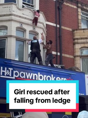 A girl was saved after falling from a window ledge in London. Video shows a restaurant manager joining a police officer as they both caught the girl after she lost her grip. #london 
