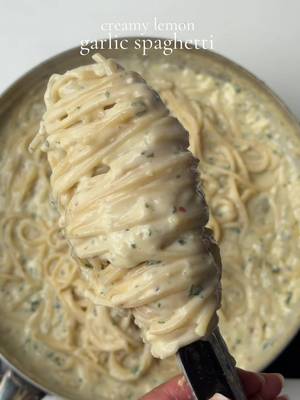 Creamy lemon garlic spaghetti  1 tbsp oil 2 tbsp butter  1/2 cup yellow onion 1 tbsp freshly minced garlic  1 1/2 tbsp all purpose flour 3/4 cup chicken broth  1 1/2 cup unsweetened heavy whipping cream, room temp Salt to taste 1/2 tsp black pepper  1 tsp garlic powder  1 tsp Italian seasoning  1 tsp parsley  3/4 cup freshly grated Parmesan cheese  1 tbsp lemon zest 2 tsp lemon juice  1 tsp red chili flakes  1 cup reserved pasta water (you may not need the full cup) 9 oz spaghetti 1 cup pasta water Method  Bring a pot of salted water to a boil. Cook the spaghetti until al dente according to the package instructions. Before draining, reserve 1 cup of the pasta water. Heat oil and butter in a large skillet over medium heat. Once the butter has melted, add the diced onion and sauté for 4–5 minutes until soft and translucent. Stir in the minced garlic and cook for 30–60 seconds until fragrant. Sprinkle in the flour and whisk continuously for about 1 minute to cook out the raw flour taste.Gradually pour in the chicken broth while whisking until the mixture is smooth. Let it simmer for 2–3 minutes until it begins to thicken slightly. Reduce the heat to low and slowly stir in the heavy cream. Add the garlic powder, Italian seasoning, black pepper, red pepper flakes, and salt to taste. Simmer for 3–5 minutes, stirring occasionally. Add the freshly grated Parmesan cheese Stir in the lemon zest. Add the lemon juice last. Add the cooked spaghetti to the skillet and toss until every strand is coated in the creamy sauce. Gradually add the reserved pasta water, a few tablespoons at a time, tossing continuously until the sauce becomes silky and perfectly coats the pasta. You may not need all of the pasta water. Taste and adjust the seasoning with additional salt, black pepper, Parmesan, or lemon juice if needed. Garnish with freshly chopped parsley, extra grated Parmesan, lemon zest, and freshly cracked black pepper. Serve immediately while hot. #spaghetti #Recipe #lemongarlic 