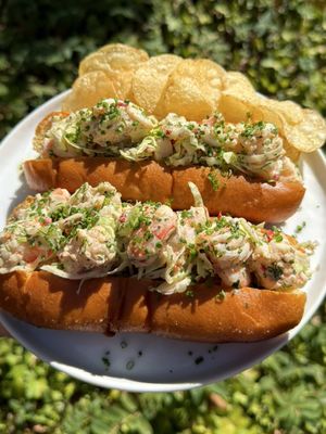 Summer Shrimp Rolls Recipe: 1 1/4 pound shrimp, peeled and deveined  6-8 toasted brioche buns Court-Bouillon  Liquid: 8 cups water 1/2 cup dry white wine 2 sprigs parsley 2 dried bay leaves 1 lemon, juiced 4 garlic cloves, crushed 1 teaspoon whole peppercorns  2 teaspoons kosher salt -Add all ingredients into a large pot and bring to a simmer on low for 15 minutes. -Add the shrimp and cook for 2-3 minutes.  -While the shrimp is cooking, prepare an ice bath with water and ice in a large bowl. -Once the shrimp is cooked, remove and add to the ice bath. Let fully cool and drain. Chop each piece of shrimp into 3 bite sized pieces. Slaw: 1/2 cup mayo  1 tablespoon Dijon mustard  zest and juice of 1 lemon  1 teaspoon Old Bay Seasoning  1 1/2 cups green cabbage, finely shredded 2 celery stalks, finely chopped  2 tablespoons pickled Fresno chili peppers, chopped  1 shallot, diced  2 tablespoons dill, chopped  2 tablespoons chives, chopped, plus more for garnish Salt and pepper to taste  -Add all ingredients to a bowl and whisk until full combined.  -Mix in shrimp and fully coat all sides.  -Add to toasted brioche buns and top with more chives. Serve with potato chips and enjoy!