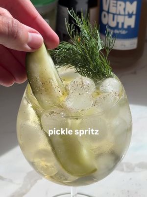 Who wants a pickle spritz? 🥒 Pickled and briney cocktails are all the rage right now. This unexpected twist on a classic spritz uses leftover pickle brine to add a tangy, salty bite that perfectly balances the bubbles. You can also make it NA by swapping the brut for soda water. Ingredients (per serving): — 3/4 oz dry vermouth — 1 oz pickle brine — 4 oz brut or champagne Add the dry vermouth and pickle brine to a chilled balloon glass with ice, then top with brut or champagne and gently stir until chilled. Garnish with a pickle spear, fresh dill, a few drops of olive oil, and freshly cracked black pepper. Enjoy! *I doubled the ingredients in the video shown* #cocktailrecipe #cocktails101 #easycocktail #picklespritz #spritz 