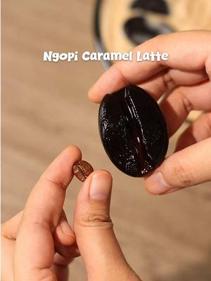 ☕️ Edible Caramel Latte 📝 Recipe 2 Sachets • Jelly Powder from Nutrijell (coffee flavored) 80g • Sugar 1000ml • Water 1 Can / 350g • Evaporated Milk 200g • Caramel Sauce Instructions: TATA CARA PEMBUATAN NUTRIJELL COFFEE :  * 		Siapkan 2 bungkus Nutrijell Coffee kemasan Reguler * 		Masukkan Nutrijell ke dalam panci * 		Tambahkan Gula sesuai selera. * 		Siapkan air sebanyak 1000ml ke dalam panci * 		Masak di dalam api sedang sampai mendidih. * 		Setelah mendidih, masukkan ke dalam cetakan berbentuk kopi. * 		Tunggu hingga set dan masukkan ke dalam kulkas selama 20 menit. TATA CARA PEMBUATAN KUAH SUSU :  * 		Siapkan wadah lainnya * 		Masukkan satu kaleng susu evaporasi ke dalam wadah * 		Kemudian tambahkan 200gram caramel sauce. * 		Lalu aduk hingga rata TATA CARA PEMBUATAN NGOPI KARAMEL LATTE :  * 		Masukkan Nutrijell Kopi yang sudah set ke dalam wadah besar * 		Lalu kemudian masukkan karamel latte yang sudah dibuat tadi. * 		Lalu tambahkan es batu sesuai selera * 		Lalu aduk hingga rata * 		Nutrijell Ngopi Karamel Latte siap disajikan. // Coffee recipe at home with IC and @nutrijell id ☕️ I never thought I could eat a coffee bean, and it’s delicious 🤤 it’s definitely worth the hype, I would eat my coffee beans all day 😋🤎 — #asmr #coffeetime #coffeebeans #NgopiCaramelLatte #NutrijellKayaSeratKayaManfaat 
