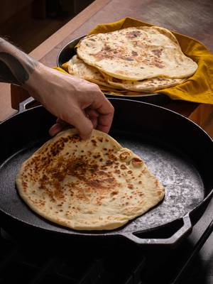 Easy yogurt flatbread 🫓  Ingredients - 260 grams all-purpose flour - 1 teaspoons salt - 1.5 teaspoons baking powder - 2 tablespoons olive oil - 200 grams plain yoghurt Add the flour, salt, baking powder, and olive oil to a bowl, followed by the plain yoghurt, and mix until you have a shaggy dough. Turn the dough out onto a board and knead until smooth, about 3-5 minutes. Cover and rest the dough for 30 minutes Divide the dough into six equal balls. On a lightly floured surface, roll each ball out into a thin flatbread. Heat a dry pan over high heat and cook each flatbread until puffed up and lightly charred on one side. Flip and continue cooking on the other side until done. Serve warm.