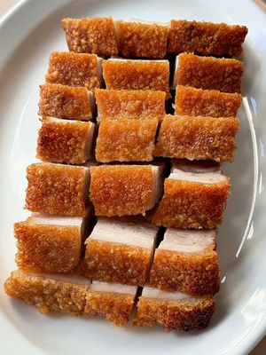 Authentic Cantonese-style Crispy Skin Pork Belly 燒肉!!  1. Holes in skin - makes sure it crackles and puffs evenly 2. Rubbing baking powder & sesame oil before roasting - makes sure it browns evenly Ingredients： 1 kg pork belly 3 tbsp shaoxing wine 2 spring onion stalks For the skin: 1/2 tsp of baking powder (not baking soda)  1/2 tsp of sesame oil For the dry rub: 1 tbsp of salt 1/2 tbsp sugar 1 tsp of five spice  1. Boil pork belly for 2 mins on medium heat to soften skin to prick holes. 2. Rub shaoxing wine and salt mixture on the meat side. Make a box with foil and leave in the fridge overnight to dry out skin.  3. The next day, rub baking powder and sesame oil on the dried skin.  4. Bake 180C for 45mins. Take out and wipe off any excess oil.  5. Then bake on top level/grill 220C for 10 mins or until skin has puffed up and is golden #crispyporkbelly #porkbelly #cantonesefood #crackling #fyppp 