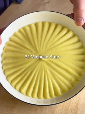 How to Make Joël Robuchon’s Mashed Potatoes ⭐️⭐️⭐️ FULL RECIPE BELOW ⬇️  Ingredients: 1.25kg ratte potato (or Yukon gold) (your yield should be 1kg after peeling) 250mL whole milk 250g unsalted butter, diced  4-5 sprigs thyme 1 tsp black peppercorns 2 cloves garlic, gently smashed Fine sea salt, to taste INSTRUCTIONS: 1. In a large, heavy bottom pot, ideally large enough to fit all your potatoes in a single layer, cover your potatoes with cold water. Bring to a boil over high heat, then lower your heat to medium. Allow your potatoes to cook for 20-30 minutes, or until you can pierce your potatoes with a pairing knife with zero resistance.  2. While your potatoes are cooking, bring your milk to a boil with your thyme, garlic and black peppercorns. As soon as it comes to a boil, turn off the heat and allow the aromatics to steep while the milk stays hot. 3. When your potatoes are done cooking, strain them, and let them sit in the strainer for 5-10 minutes to allow steam to be released. Once they are cool enough to touch, but still hot, peel the potatoes & discard the skins. 4. Press your potatoes through a potato ricer into a large bowl. Strain the aromatics out of your milk, and pour half of the milk into the riced potatoes. Fold the milk gently into the potatoes until incorporated. Then, pass your potatoes once more through a fine mesh strainer into a large pot (this step is optional, but does result in THE smoothest potatoes). 5. Put the pot over low heat, and add more milk as needed until your potatoes are smooth. At this point, you can decide how smooth/luxurious you would like your potatoes. If you want them to be more of a "purée", add all of the butter and remaining milk for the true Joel Robuchon Ratio. If you want more of a traditional mashed potato consistency, add less milk, and half the butter. Regardless of what you choose, at this point you can season your potatoes with salt to taste. Serve your potatoes as a side with any roast or braised meat, and enjoy!  #mashedpotatoes #michelin #potato #homecooking #Recipe 