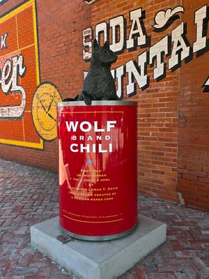 🔥 As a lifelong chili lover, a stop in Corsicana, Texas, is practically mandatory. 🛣 🥫 Wolf Brand Chili got its start on a farm just outside of Corsicana in 1895 when 12-year-old Lyman T. Davis and his range cook developed the soon-to-be-famous recipe. The pair brought bubbling cauldrons full of the stuff into town and sold it from the back of a wagon beside the Blue Front Saloon. That original location is marked today by a large steel and bronze Wolf Brand Chili monument at the corner of Beaton Street and 5th Avenue. Davis sold his chili for five cents a bowl, and the monument is topped with a statue of Kaiser Bill, his pet wolf. Local lore says rubbing KB’s paw even brings good luck. 🐺 🌶 In the 1920s, Davis began putting his chili into cans labeled “Wolf Brand Chili,” a name that remains on store shelves today. The company stayed locally owned until 1957 before eventually becoming part of Conagra Brands, which now produces several varieties of its famous “bowl of Texas.” 🥣 On the same corner, Across the Street Diner occupies a historic building that once housed Hashop’s Pharmacy and Soda Fountain. The classic diner serves comfort food alongside bowls of Wolf Brand Chili. It is, of course, without beans. 🫘 After exploring downtown, I popped over to the Pioneer Village Museum at 912 West Park Avenue. The historical complex houses the vintage Wolf Brand Chili truck alongside 1800s pioneer cabins and local museums. 🛻 🤠 To learn more about "Texas Chili: What it is, What it Isn’t & Why I’m Obsessed With the State’s Favorite Dish", visit the link below for my article for @HoustonFoodFinder. https://houstonfoodfinder.com/foodfinds/texas-chili-what-it-is-what-it-isnt-why-im-obsessed-with-the-states-favorite-dish/ ✍️🏽 @MadmanMario #HFFOnTheRoad #CorsicanaTX #WolfBrandChili