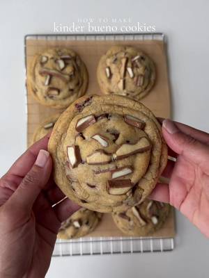 Kinder bueno cookie 🍪  Ingredients For the cookie dough: 227g cold European unsalted butter, cubed 180g brown sugar 110g granulated sugar 1 large egg + 1 large egg yolk 1 tbsp vanilla bean paste 405g all-purpose flour 1 tsp espresso powder 1 tsp baking powder 1/2 tsp baking soda 1/2 tsp salt 1 tsp cornstarch 1 cup semi sweet chocolate chips 5–6 Kinder Bueno bars, chopped into small pieces For the filling: 3/4 cup hazelnut chocolate spread Kinder wafer chocolate  For topping: Extra Kinder Bueno pieces Method  Line a small tray with parchment paper. Scoop the hazelnut spread into about 10 small portions, roughly 1 tablespoon each. Freeze for at least 30–45 minutes, until firm. Make the dough: Preheat your oven to 350°F (175°C) and line two baking trays with parchment paper. In a large mixing bowl, combine the cold cubed butter, brown sugar, and granulated sugar. Using a paddle attachment, beat on medium speed for 2–3 minutes, until combined and creamy-looking. Add the egg, egg yolk, and vanilla bean paste. Mix until fully incorporated, scraping down the bowl as needed. In a separate bowl, whisk together the flour, espresso powder, baking powder, baking soda, salt, and cornstarch. Gradually add the dry ingredients to the wet ingredients. Mix on low speed just until the flour disappears. Don't overmix. Fold in the semi-sweet chocolate chips and chopped Kinder Bueno pieces. Divide the dough into approximately 10 portions. Flatten each portion slightly, place one frozen hazelnut-spread portion in the center, along with kinder wafer chocolate then fold the dough completely around it. Seal well and roll into a tall, thick ball. For the thickest bakery-style result, chill the shaped cookies for 30–60 minutes Place the cookies on the prepared baking trays, leaving plenty of space between them.. Bake at 350°F (175°C) for about 15 minutes, until the edges are golden brown and set while the centers still look slightly soft. Let the cookies cool on the baking tray for 10–15 minutes, then transfer to a wire rack. #cookies #kinderbueno #Recipe 