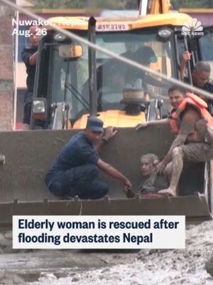 An elderly woman was rescued by an excavator following devastating flash floods in Nepal.