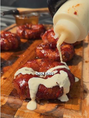 Getting ready for Labor Day weekend? Try these Texas Stuffed Onion Rings 🥓🔥    Recipe: -Mix together 1.5 lbs cooked spicy breakfast sausage, 2 small jalapeños, diced, 8 oz cream cheese, ¼ cup cheddar cheese shredded, 2 tsp kosher salt, 1 tsp black pepper, 1 tsp garlic powder to make the filling. -Slice onions into 1 inch rings, using large and smaller pairs to make the shape. -Take the bigger outside rings and press the filling against the inside, then put a smaller ring in the middle to create the donut shape. -Wrap bacon around the rings and sprinkle bbq rub, and place in the fridge for 30 minutes. -Place them on the smoker at 300F and cook for 1 hour or until the bacon is done, painting with BBQ sauce near the end of the cook. -Serve with ranch and enjoy.