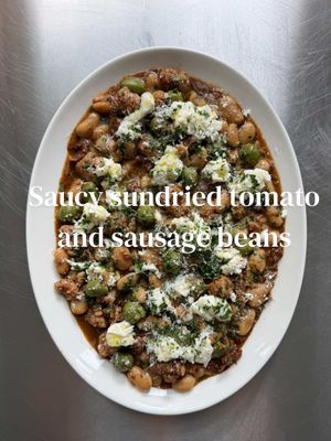 If there’s one place I love an olive more than in a martini, it’s swimming around with a load of beans. This is my saucy sun-dried tomato, olive, sausage and creamy butter beans. Rich, salty, cosy business and absolutely screaming for a loaf of bread. 3-4 5 good-quality pork sausages 1 glass white wine  4 garlic cloves, finely chopped 1 tbsp fennel seeds 1 tbsp dried oregano 100g sun-dried tomatoes, roughly chopped 100g Nocellara olives, pitted (or any olive you like) 1 jar Bold Bean Co butter beans, with their bean stock 200ml chicken or vegetable stock (OR 1 x 400g tin/jar drained butter beans + 500ml stock) Handful of flat-leaf parsley, chopped Parmesan 1 ball mozzarella, torn 1. Heat a drizzle of olive oil in a large frying pan. Add the sausages and cook until deeply golden and crispy all over. Remove from the pan and set aside.  2. Deglaze the plan with a glass of wine, then add the fennel seeds, garlic, oregano, sun-dried tomatoes and olives to the sausage fat and cook for 2 mins until fragrant.  3. Pour in the butter beans along with their bean stalk, followed by 200ml stock. If using drained beans instead, add them with around 500ml stock. 4. Return the sausages to the pan, bring to a simmer and cook for 8-10 mins, until the sauce has reduced and become rich, glossy and slightly creamy from the beans. Season taste 5. Plate up and finish with plenty of chopped parsley, grated Parmesan and torn mozzarella and a final drizzle of good olive oil