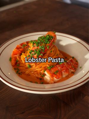Feeding you pasta and lobster🦞🍝 Ingredients Fresh Pasta - 1 cup 00 flour - 7 egg yolks or 3 whole eggs - Olive oil - Chives Lobster Cream - 2 lobsters - 2 shallots - Garlic - 1 large carrot - 1 tbsp tomato paste - 1 cup Cognac (optional) - 500 ml heavy cream - Tarragon - Thyme - 1 bay leaf - Cherry tomatoes - Butter - Chilli Instructions Lobster Cream 1. Boil the lobster tails for 4 minutes and the claws for 5 minutes. Transfer immediately to ice water to stop the cooking. 2. Crack the shells and gently remove the meat. Set aside. 3. Heat a drizzle of olive oil in a pan. Add the carrots, shallots, garlic, and lobster shells. Cook until softened. 4. Deglaze with Cognac and let the alcohol cook off. 5. Add the heavy cream, tarragon, thyme, and bay leaf. Simmer gently for 1 hour. 6. Strain through a fine sieve and set the lobster cream aside. Fresh Pasta 1. Place the flour on a work surface and make a well in the centre. Add the egg yolks. 2. Gradually incorporate the flour and knead until you have a smooth dough. 3. Wrap tightly and rest for 1 hour. 4. Cut the dough in half and roll each piece into a thin sheet. 5. Cut into tagliolini using a pasta machine or by hand. Assembly 1. Heat a drizzle of olive oil in a pan. Add the chopped shallots, garlic, chilli, and tarragon. 2. Add the tomato paste and cook for 1–2 minutes. 3. Add the cherry tomatoes and cook until softened. 4. Pour in the lobster cream and gently simmer. 5. Cook the pasta in salted boiling water for 2–3 minutes. 6. Add the pasta to the sauce with 2 tbsp of pasta water. Toss until well coated.
