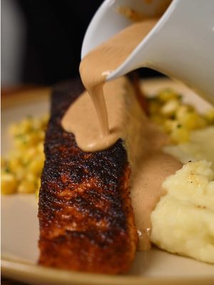 Cheesecake Factory at home! Cajun blackened salmon, buttery mashed potatoes, sweet corn, and a rich Cajun cream sauce. So good! Cajun Blackened Salmon * 2 salmon fillets * Cajun seasoning * Olive oil + neutral oil Coat salmon with olive oil and generously season with Cajun spice. Sear in a hot pan with neutral oil, using a weight for maximum contact and a deep, blackened crust. Flip, cook about ¾ of the way through, and set aside. Creamy Mashed Potatoes * Yukon Gold potatoes * Butter + heavy cream * Salt Peel and cut potatoes, then start in cold, generously salted water. Boil until tender, drain, and rice. Fold in warm melted butter and cream, whip until smooth, and season to taste. Buttered Corn * Fresh corn, kernels removed * 1 tbsp butter * 1 tbsp chopped chives * Salt Add corn to a pan with a splash of water. Cover and steam until nearly evaporated, then toss with butter, chives, and salt. Cajun Cream Sauce * Butter * Shallots + garlic * Chili flakes * Heavy cream * Cajun seasoning + paprika * Lemon juice Pour off excess oil from the salmon pan. Add butter, shallots, garlic, and chili flakes. Sweat until fragrant, then add cream, Cajun seasoning, and paprika. Simmer until slightly thickened and finish with lemon juice. Plate the mashed potatoes, add buttered corn and blackened salmon, then finish with a generous drizzle of Cajun cream sauce. Enjoy! #EasyRecipes #cheesecakefactory #cajunsalmon 
