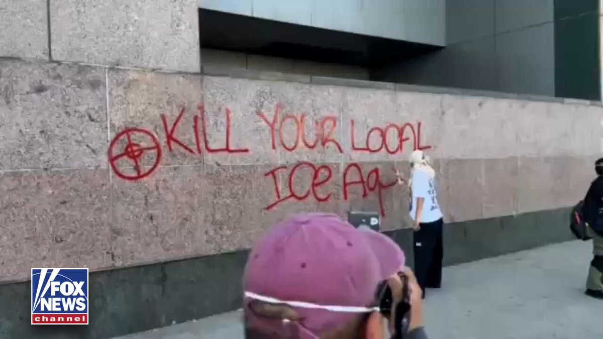 DIRECT THREAT: An agitator spray-paints "kill your local ICE agent" on the side of a federal building in Los Angeles as thousands marched through the city's downtown for the "No Kings" protest. 