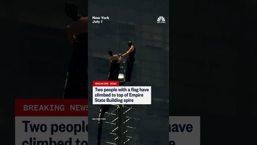 Two people climb the Empire State Building spire