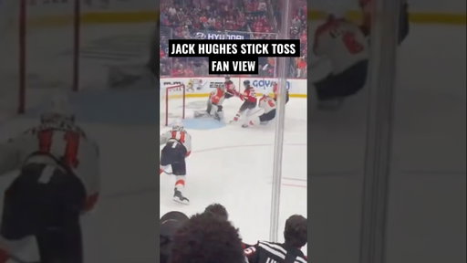 Jack Hughes of the New Jersey Devils gives a fan a souvenir after his OT goal