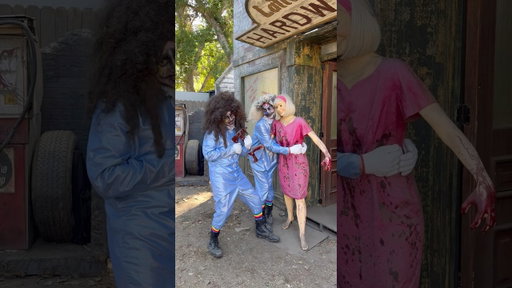 Two clowns in makeup talking to a dead statue woman